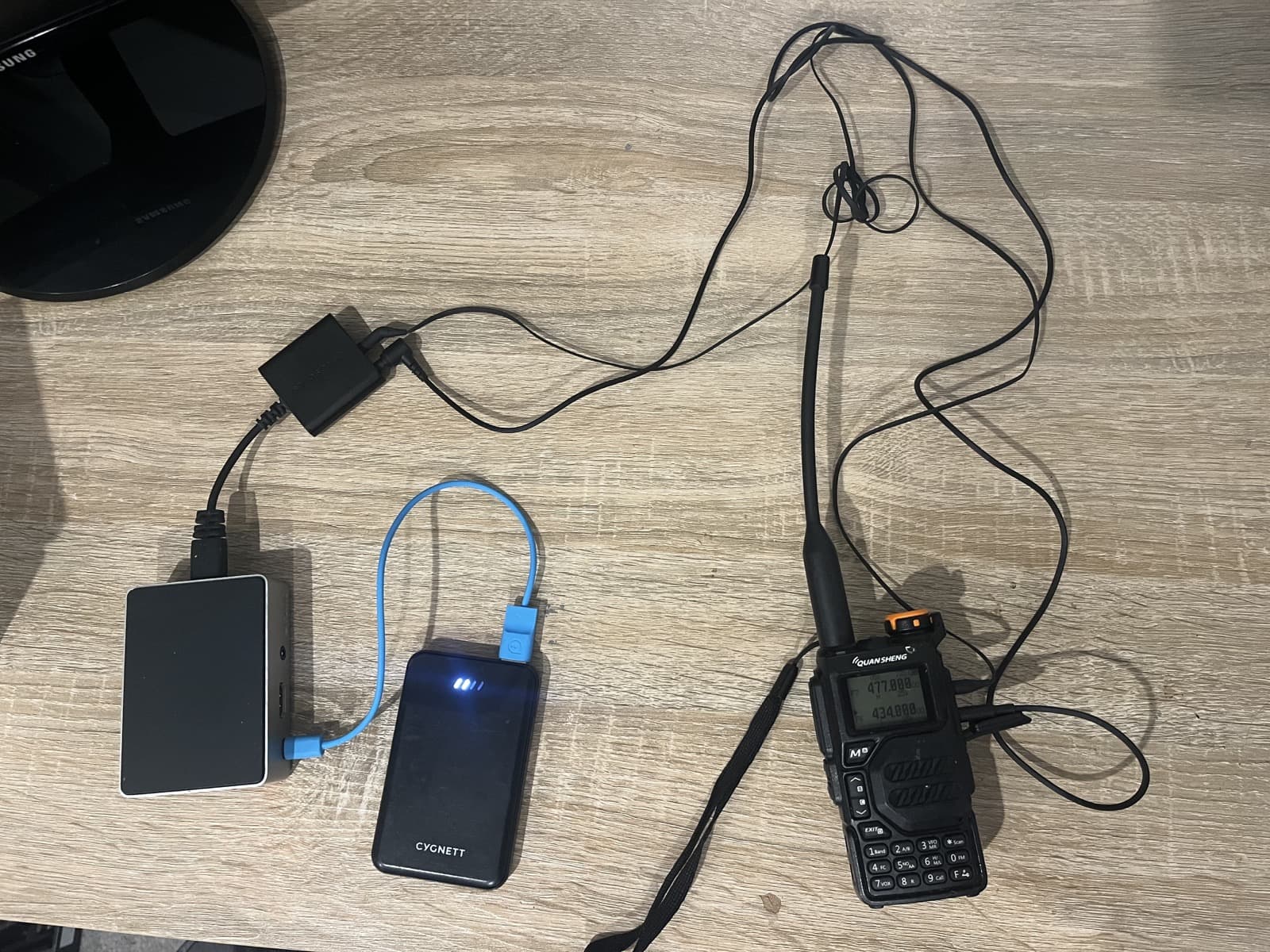 Raspberry Pi field node hardware with a battery pack, cables, and a handheld radio.