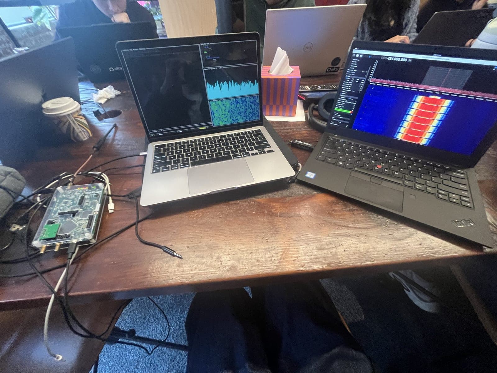 Laptops, radio hardware, cables, and waterfall displays from the TrailLink bench test setup.
